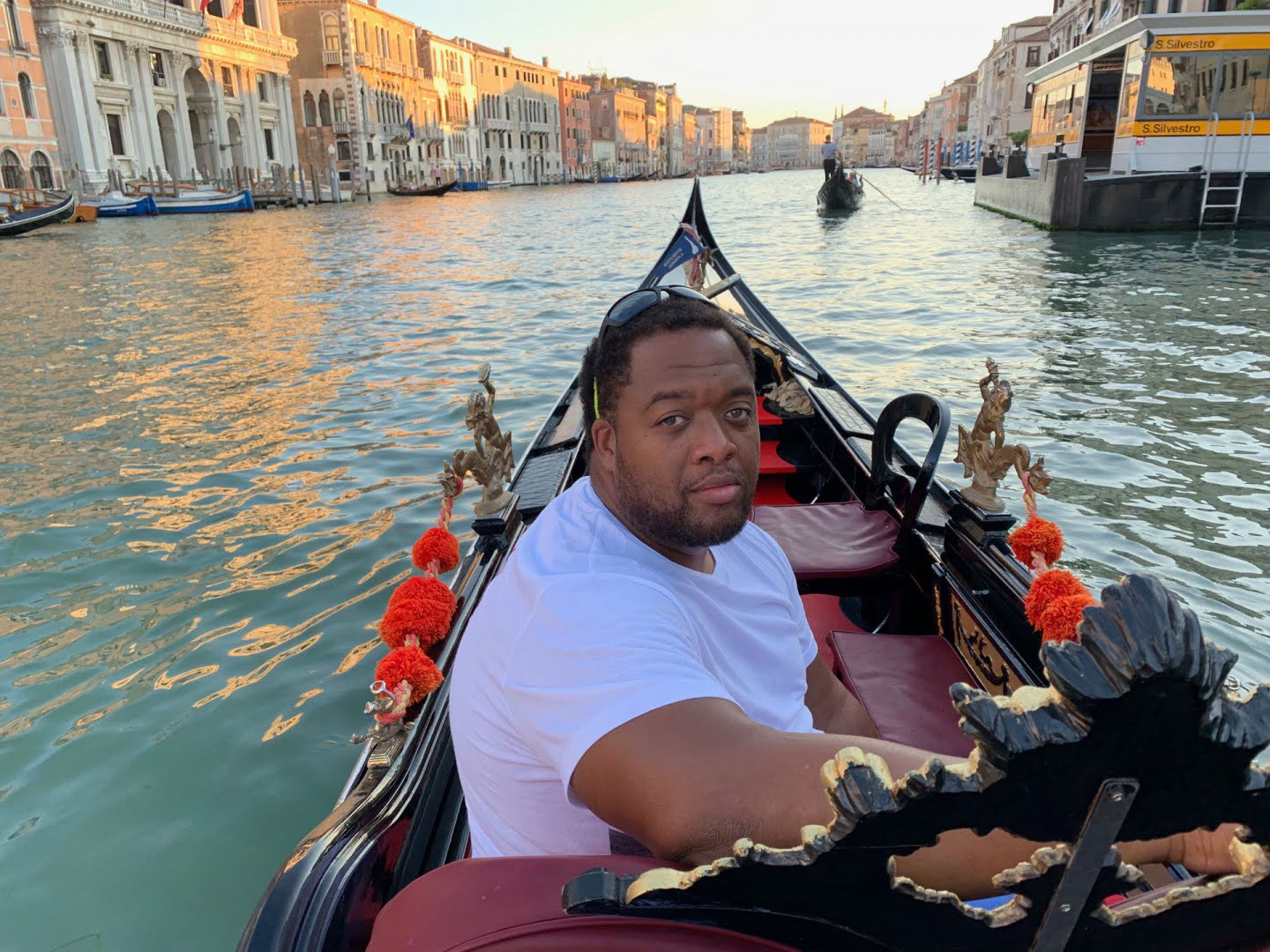 Christopher Lafayette seated in a gondola on a Venetian canal.